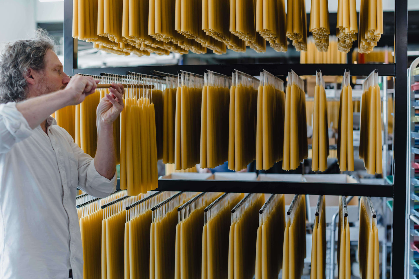 Jon kornbluh hands pure beeswax taper candles on the rack