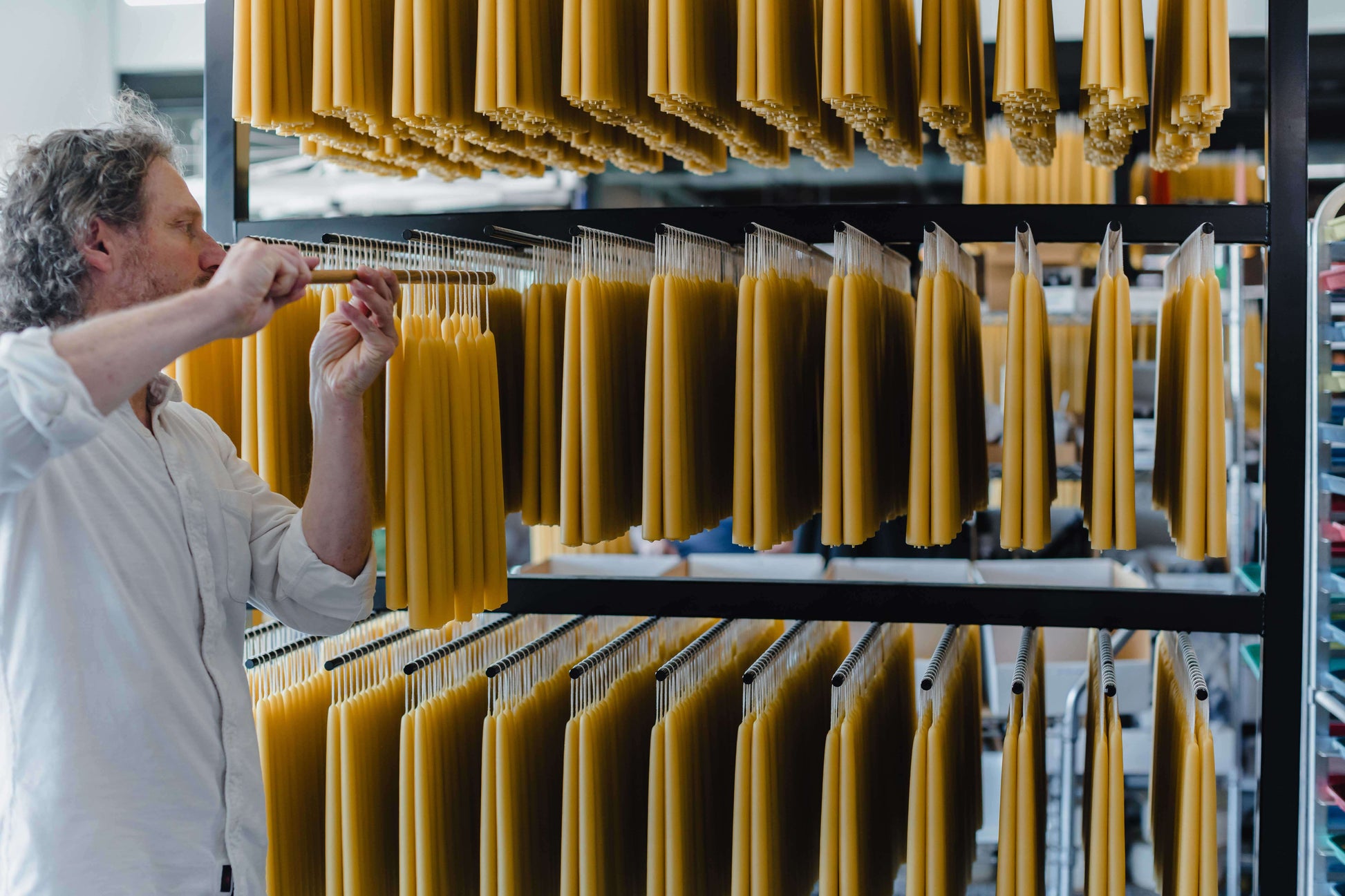 Jon kornbluh hands pure beeswax taper candles on the rack