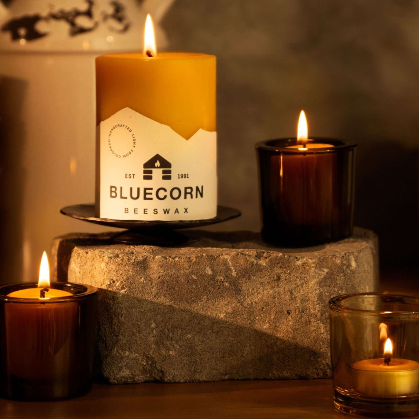 beeswax votive candles in dark amber votive holders alongside pure beeswax pillar and tea light