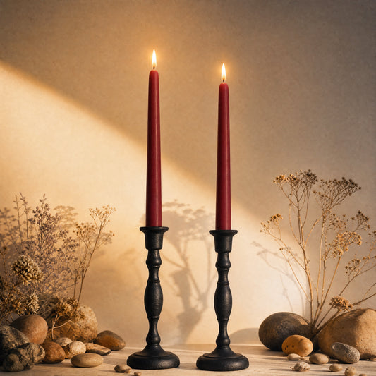 two burgundy tapered beeswax candles in cast iron holders