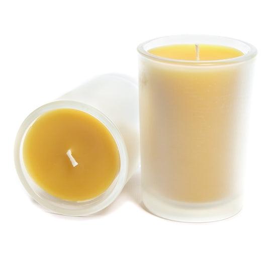 Two beeswax candles in frosted glass depicting the side and top view of Bluecorn Beeswax's 8.5oz pure beeswax candle. Wax is golden yellow and shows through only slightly in the frosted glass.