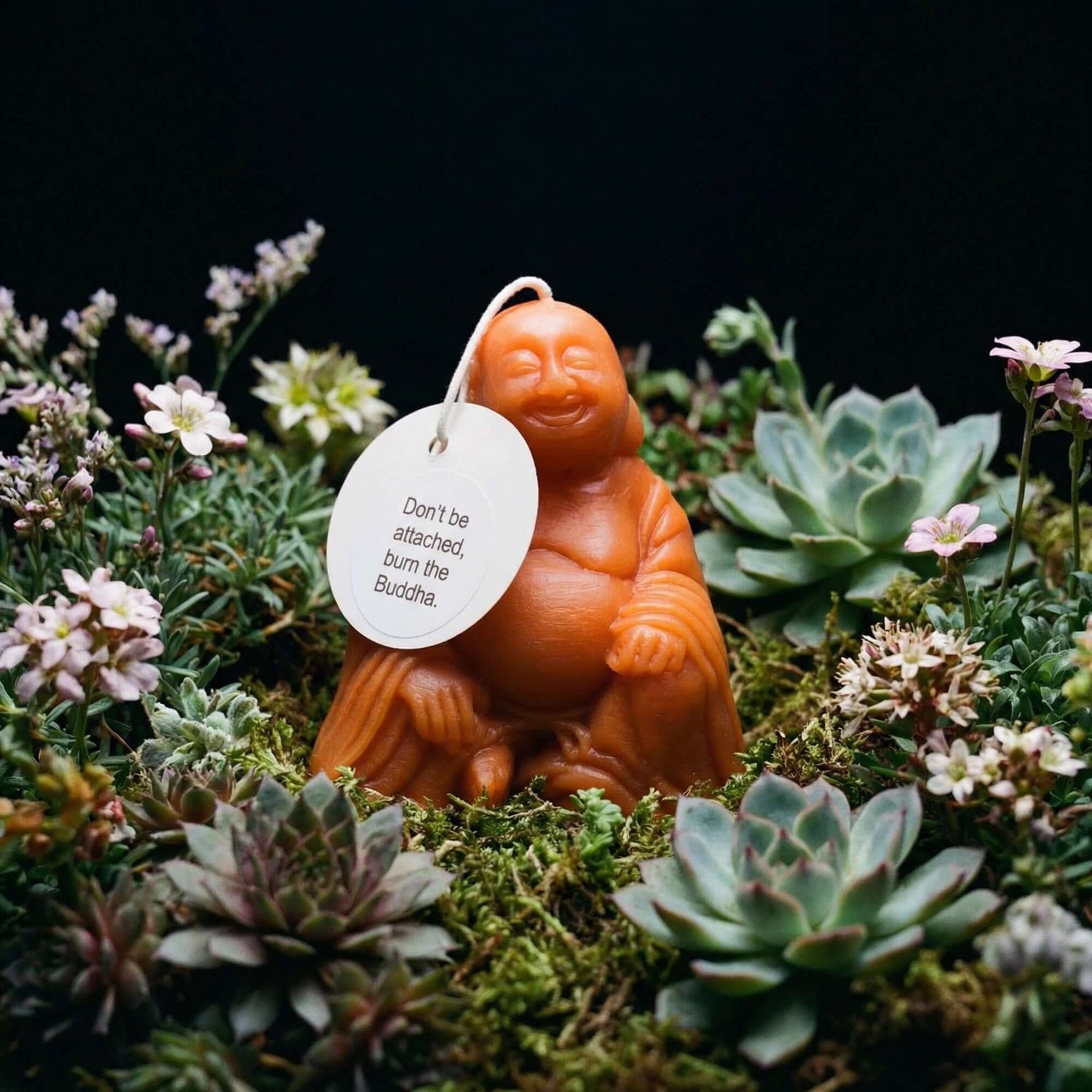 bluecorn buddha shaped molded beeswax candle in apricot with charming hang tag that reads don't get attached, burn the buddha 