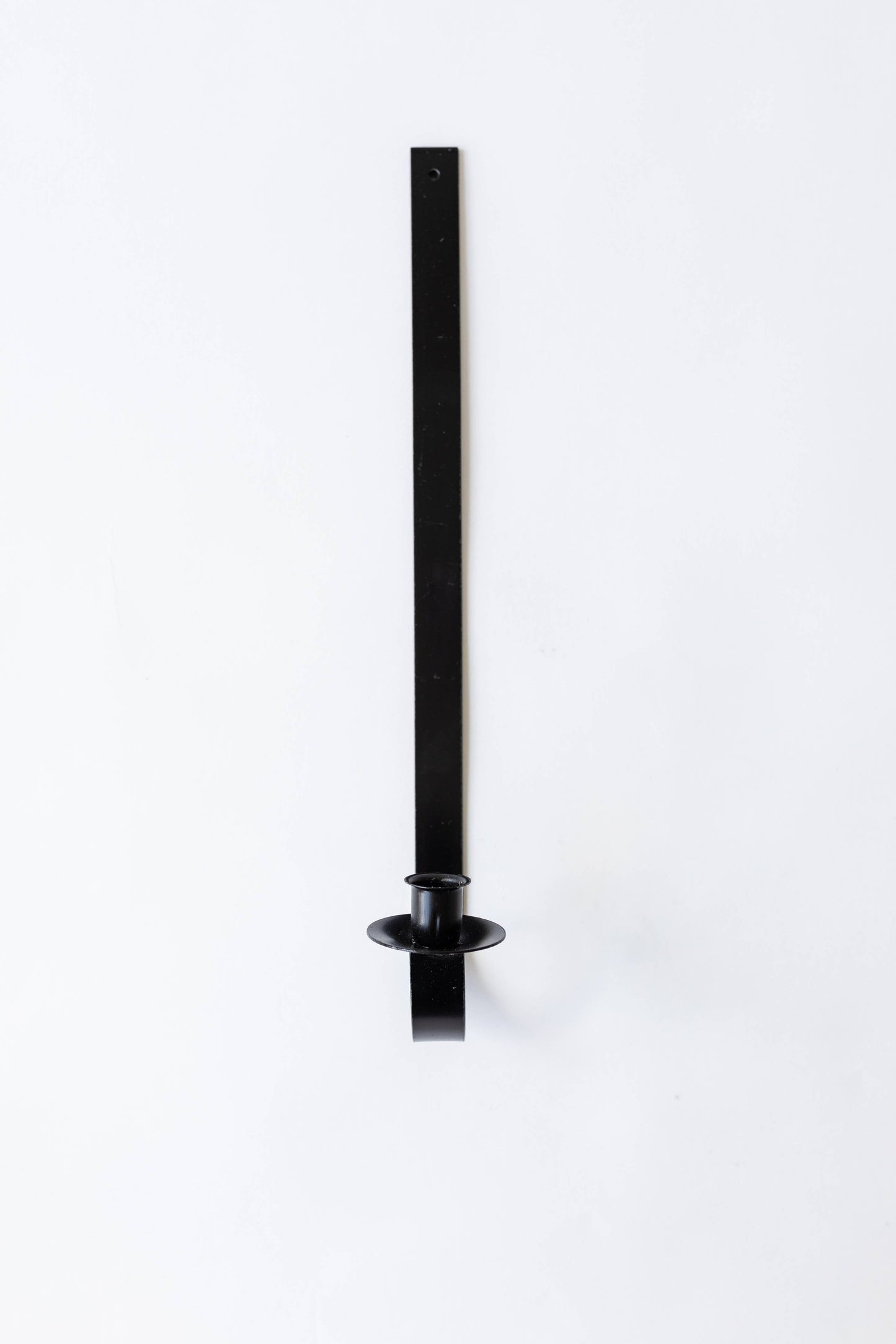Black iron wall-mounted tapers for candles holder on a white background. Hand-forged by Amish artisans for Bluecorn Candles.