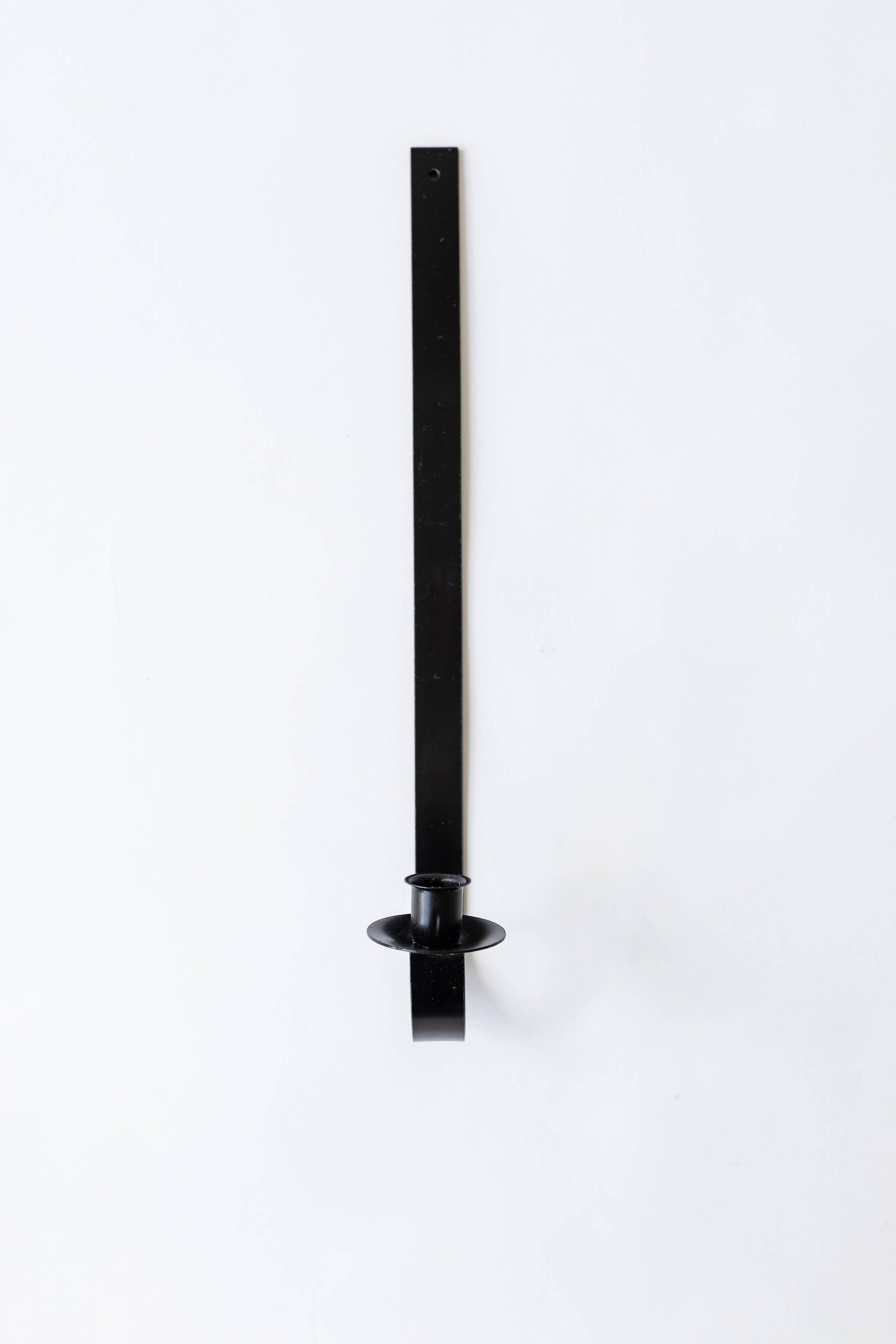 Black iron wall-mounted tapers for candles holder on a white background. Hand-forged by Amish artisans for Bluecorn Candles.