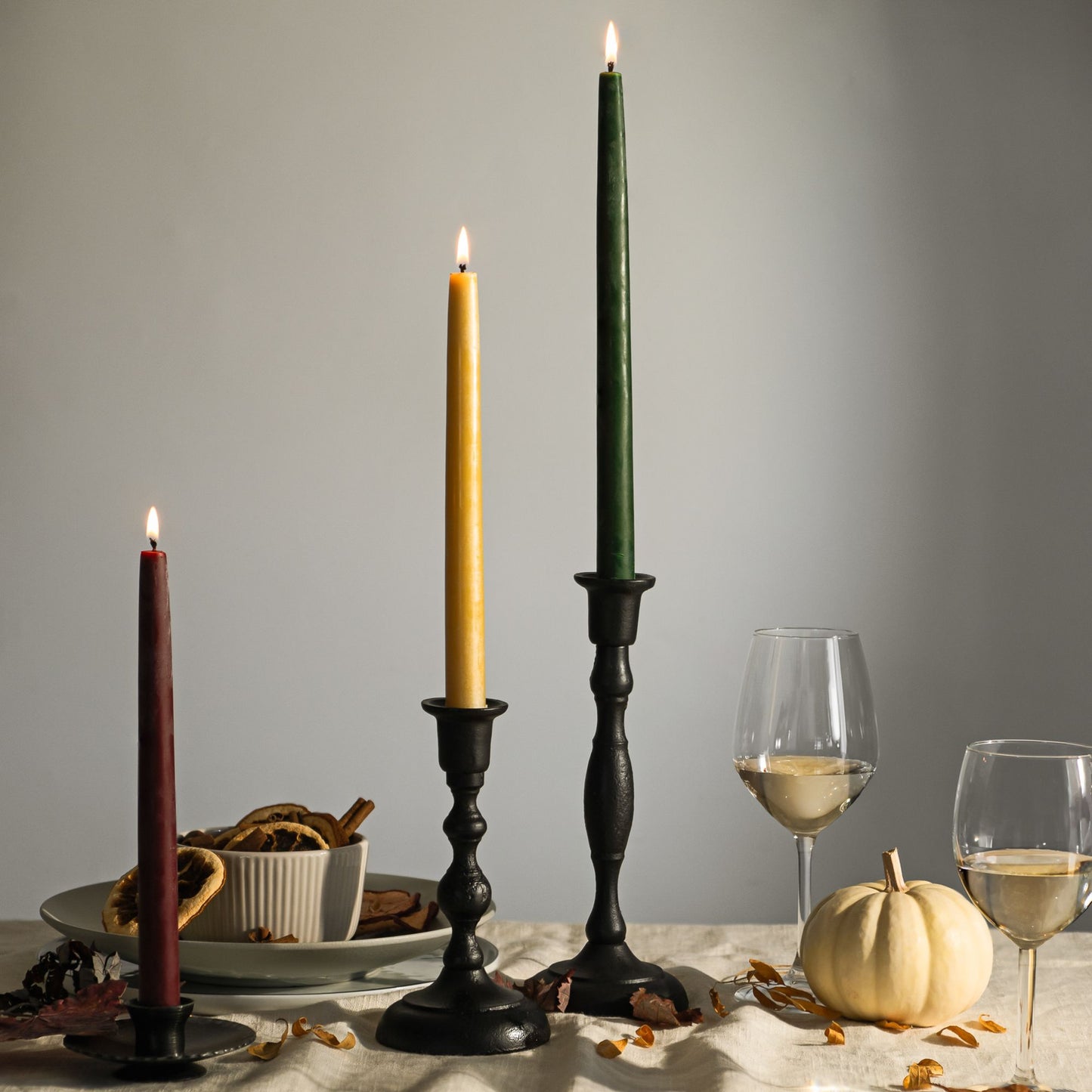 pure beeswax taper candles in moss, gold and burgundy on a fall holiday table