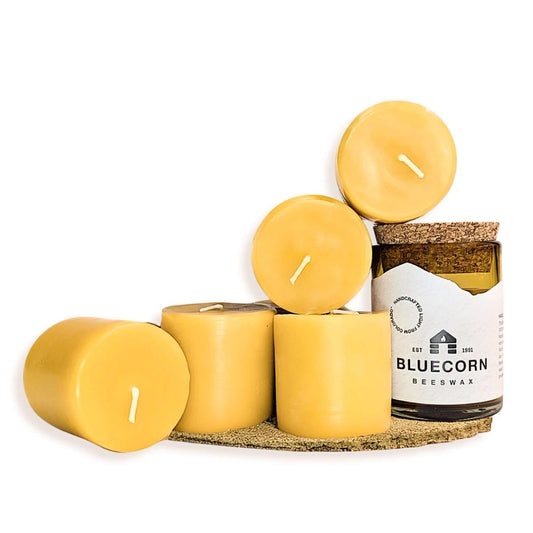 Set of yellow candles on a cork tray with a Bluecorn Beeswax candle jar.