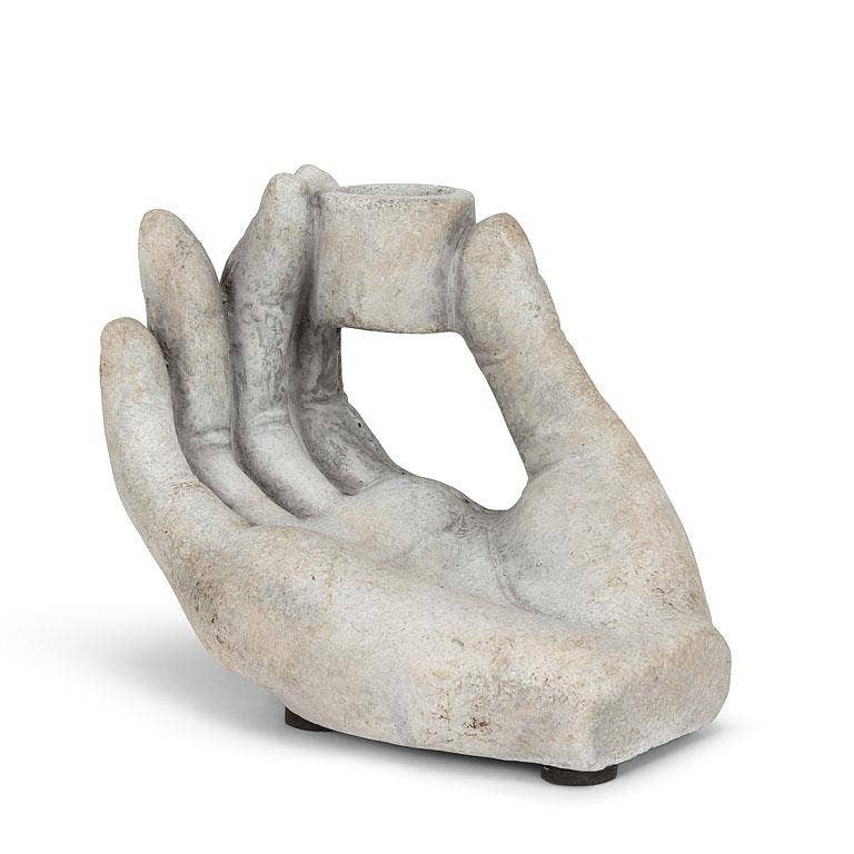 Decorative stone hand holding a candle on a white background
