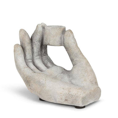Decorative stone hand holding a candle on a white background