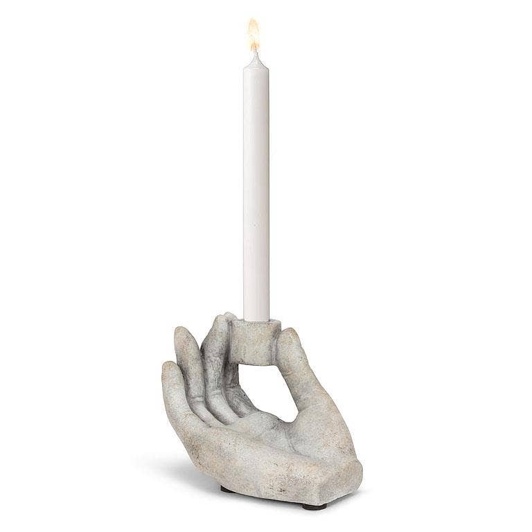 Candle holder shaped like a hand holding a candle on a white background