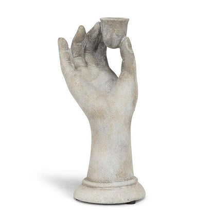 Decorative stone hand holding a small cup on a white background
