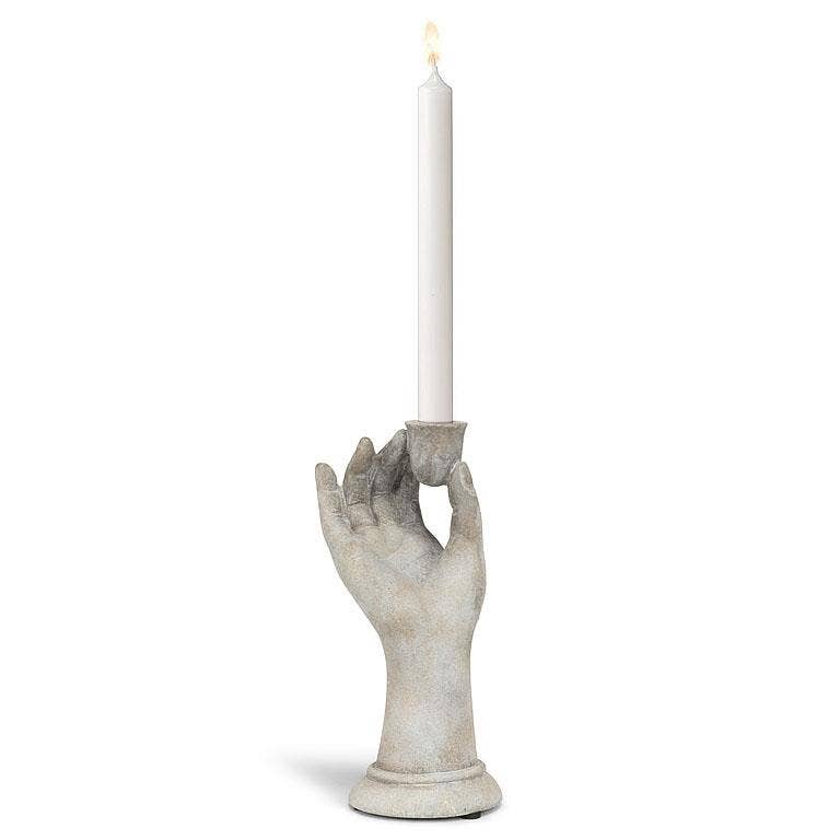 Decorative candle holder shaped like a hand holding a candle on a white background