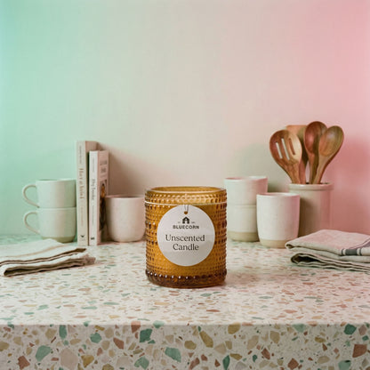 Unscented refillable candle in knobby amber glass with warm candlelight glow