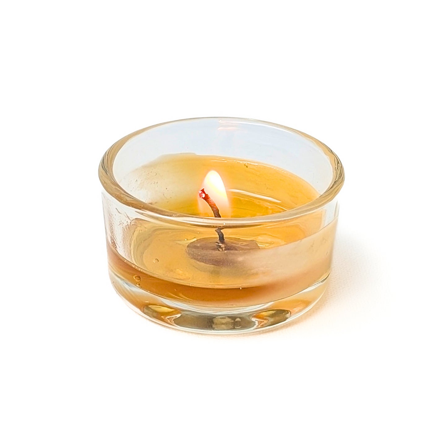 bluecorn beeswax tea light in refillable glass holder midway through the burn
