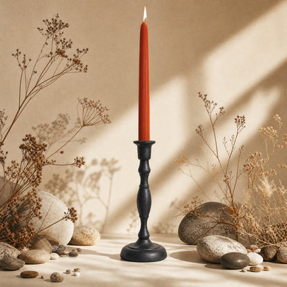 terracotta colored beeswax taper candle in cast iron candlestick holder