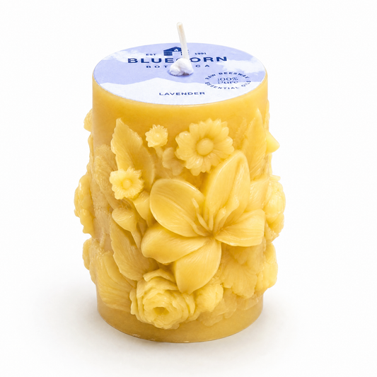 pure beeswax pillar candle sculpted with floral motif and scented with lavender essential oil bluecorn botanica label on top