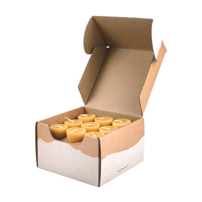 An open box of 18 pure beeswax votive candles made from premium raw beeswax in a Bluecorn Beeswax craft box.