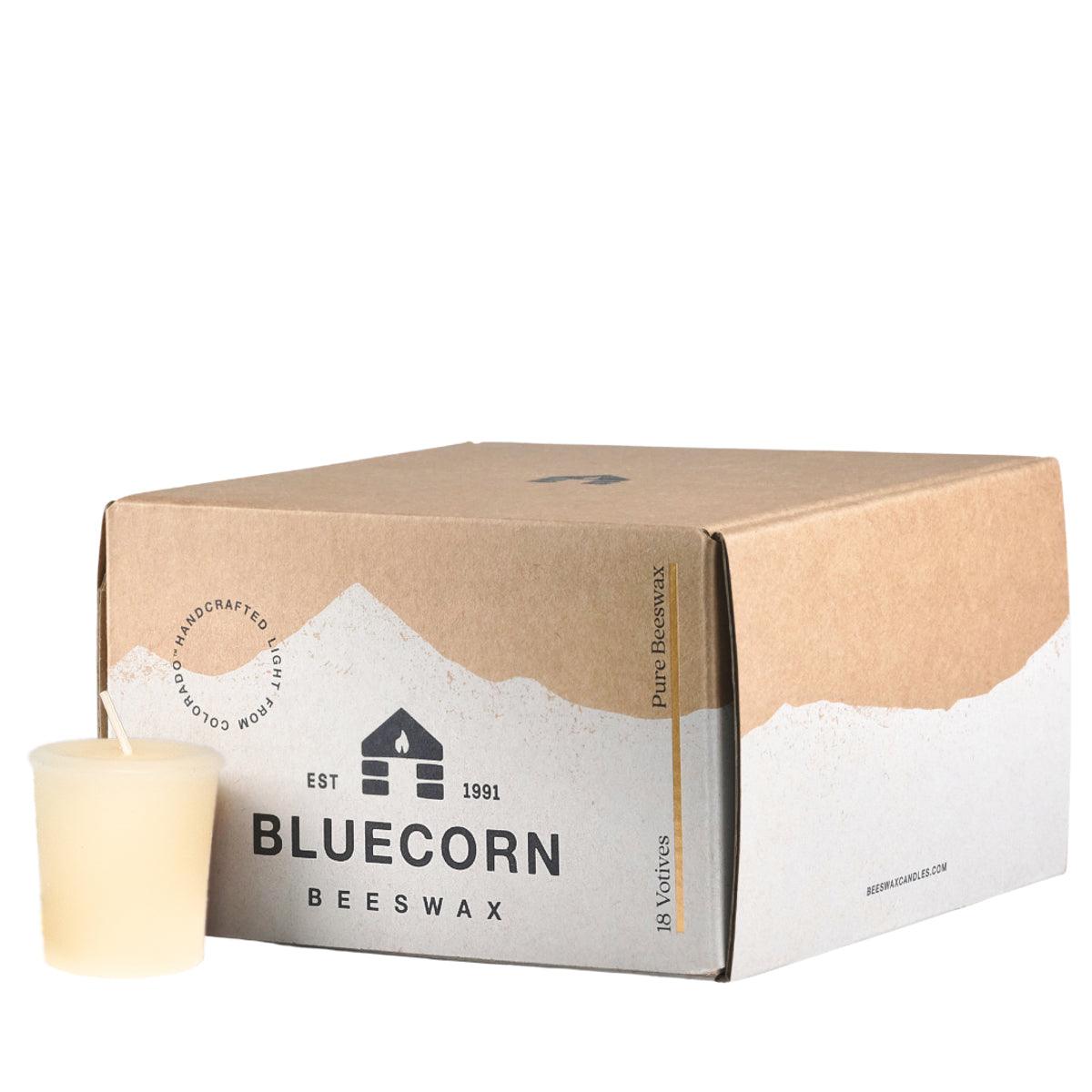 A single beeswax votive in the color ivory, sitting next to a closed 18-pack votive box