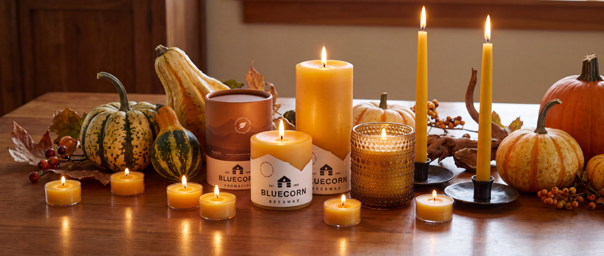 pure beeswax pillars, tapers and tea lights on a thanksgiving table with bluecorn beeswax logo and packaging