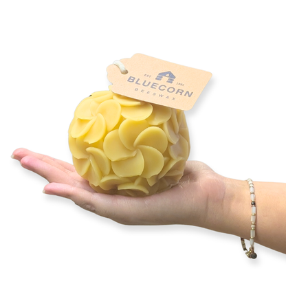 Hydrangea shaped candle crafted from beeswax, showcasing a perfect round design held in a hand.