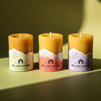 scented beeswax pillar candles from bluecorn, eucalyptus and orange, cypress and sandalwood, lavender essential oil on green background