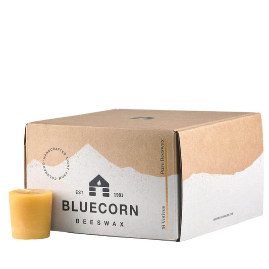 beeswax votive candle next to a Bluecorn Beeswax 18-pack beeswax votive candles bulk box